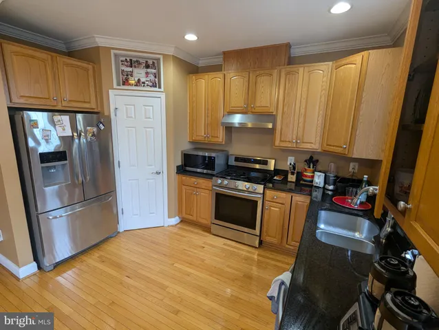 a kitchen with stainless steel appliances granite countertop a refrigerator stove and sink
