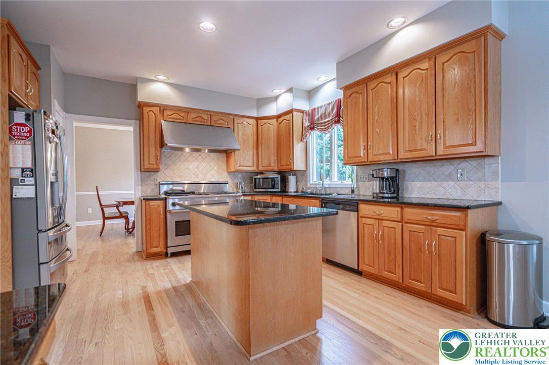 6551 Overlook Road Orefield, PA 18069 - Photo 20 of 82 a kitchen with stainless steel appliances granite countertop a stove a sink dishwasher and a refrigerator with wooden floor