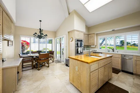 a kitchen that has a lot of cabinets in it and stainless steel appliances