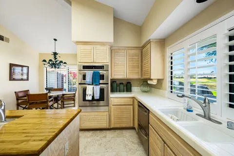 a large kitchen with kitchen island a large counter space appliances and a large window