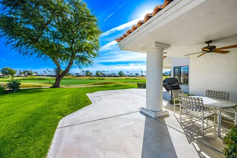 a view of a patio with a table and chairs under an umbrella