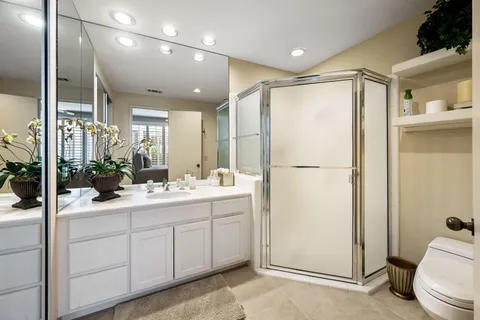 a bathroom with a double vanity sink toilet and shower