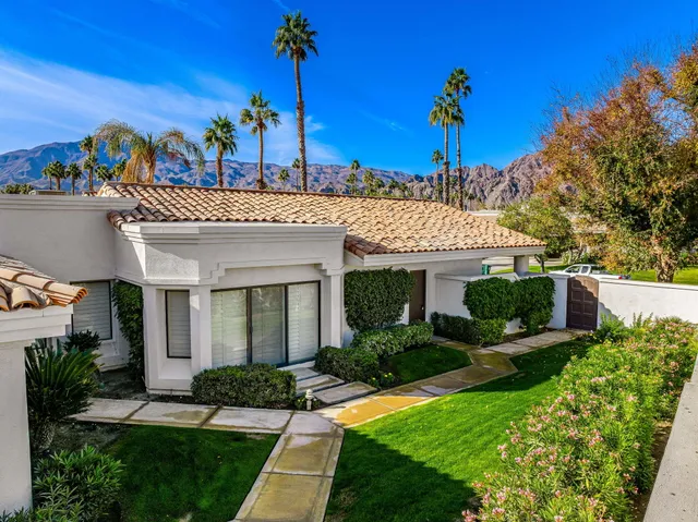 a view of a house with a yard and potted plants