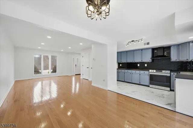 a large kitchen with stainless steel appliances granite countertop a large counter top a stove and a sink