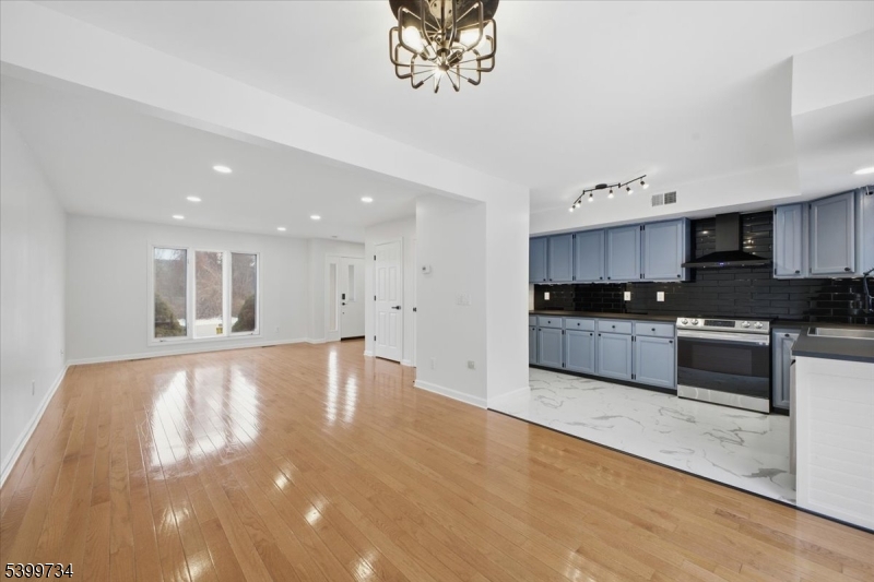 a large kitchen with stainless steel appliances granite countertop a large counter top a stove and a sink