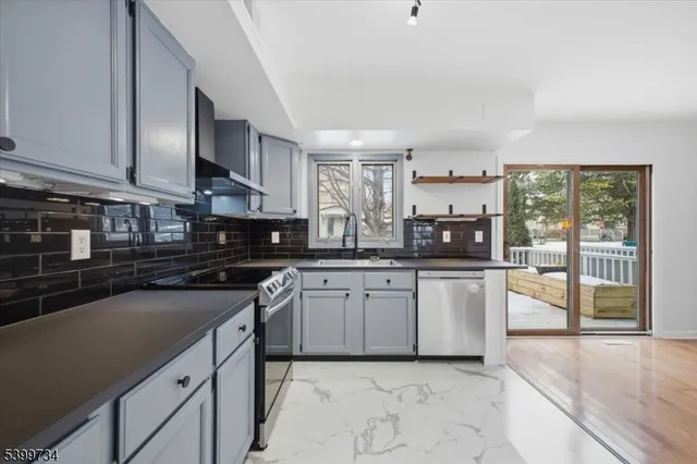 a kitchen with stainless steel appliances granite countertop a stove sink and cabinets
