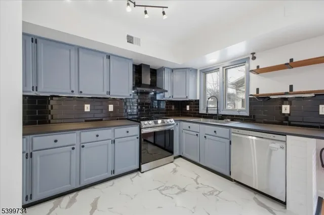 a kitchen with stainless steel appliances granite countertop a sink a stove a microwave a counter top space and cabinets