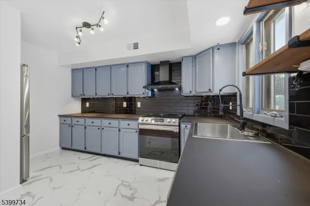 a kitchen with stainless steel appliances granite countertop a stove sink and cabinets