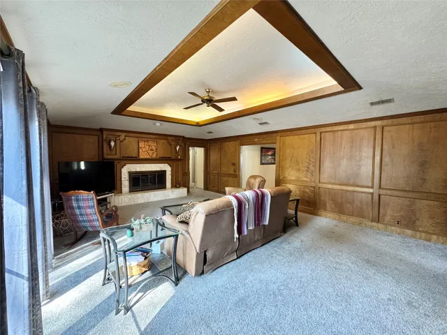 a living room with furniture a flat screen tv and large window