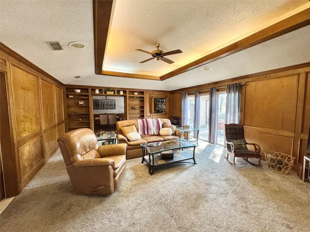 a living room with furniture a ceiling fan and a window