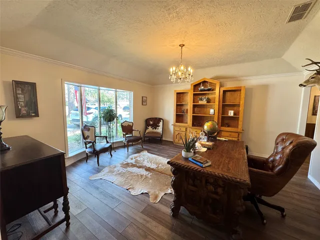 a living room with furniture a dining table and a chandelier