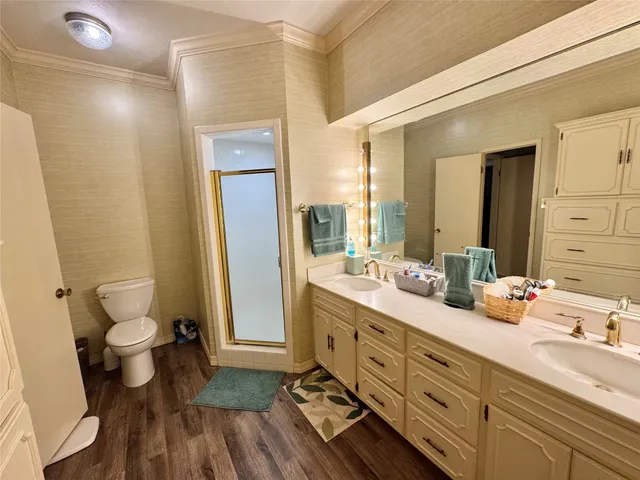 a spacious bathroom with a double vanity sink a mirror and a toilet