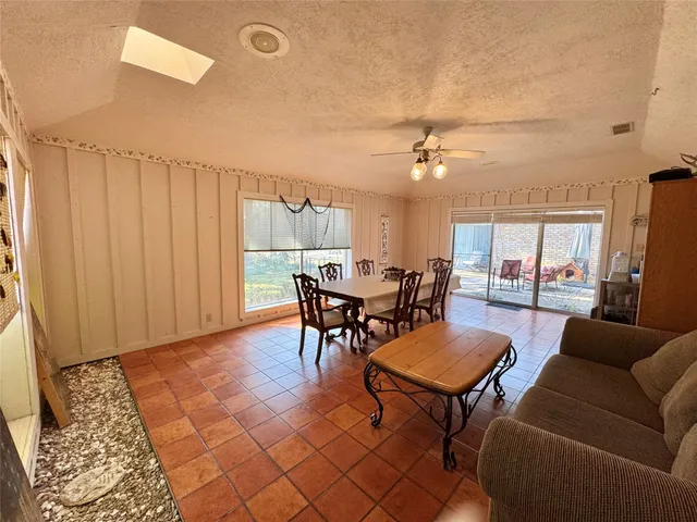 a living room with furniture a chandelier and a dining table