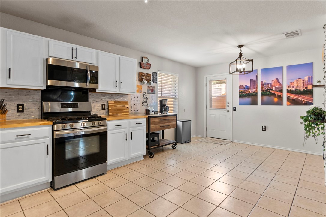 5908 Silver Screen Drive Austin, TX 78747 - Photo 11 of 24 a kitchen with granite countertop a stove top oven microwave and cabinets