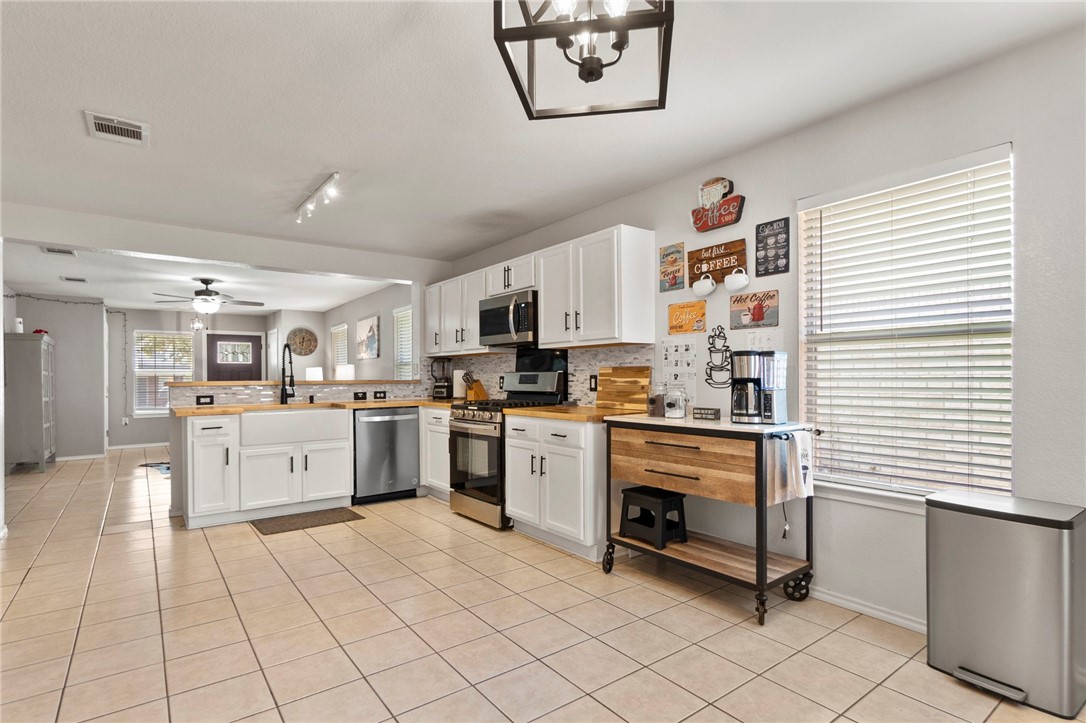5908 Silver Screen Drive Austin, TX 78747 - Photo 12 of 24 a kitchen with white cabinets and white appliances
