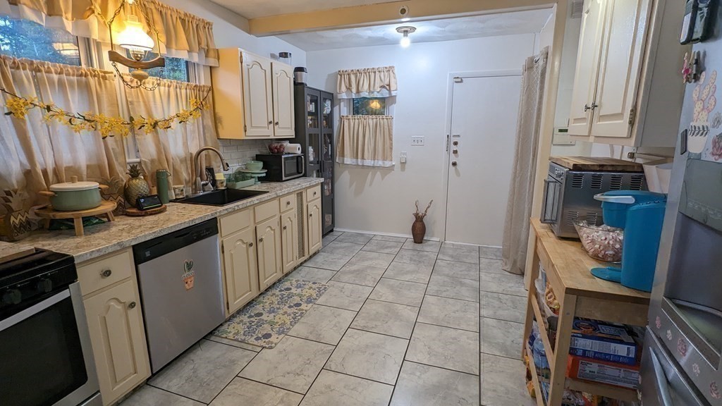 28 Bushwick Place Springfield, MA 01109 - Photo 6 of 24 a kitchen with stainless steel appliances a sink and a refrigerator