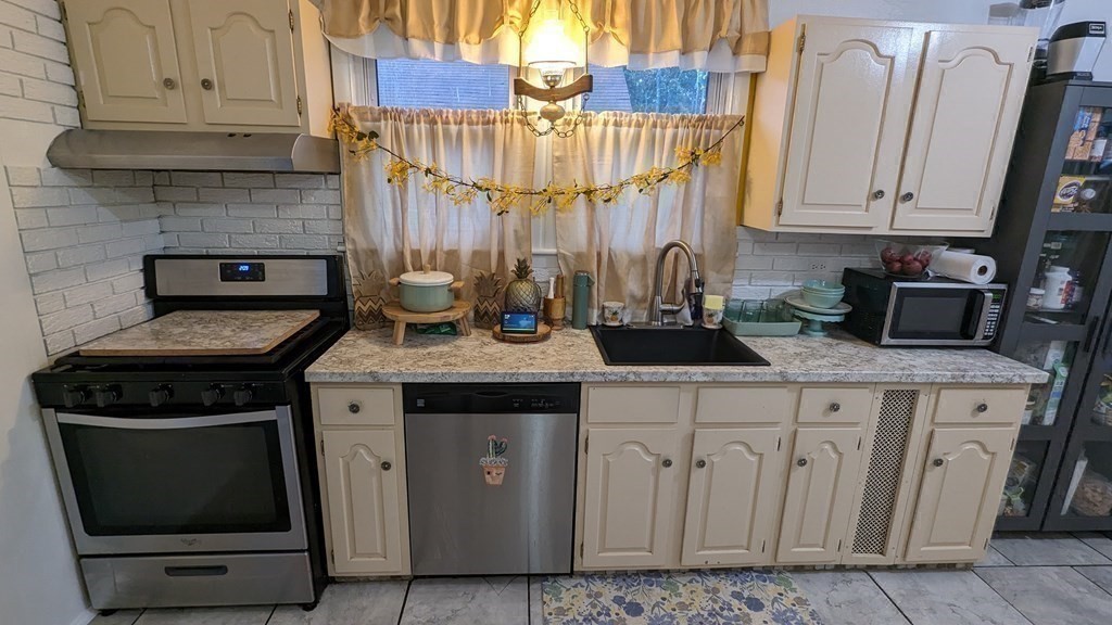 28 Bushwick Place Springfield, MA 01109 - Photo 7 of 24 a kitchen with a stove and cabinets