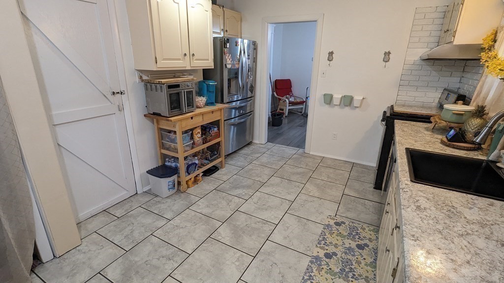 28 Bushwick Place Springfield, MA 01109 - Photo 8 of 24 a kitchen with stainless steel appliances a stove a sink and a refrigerator