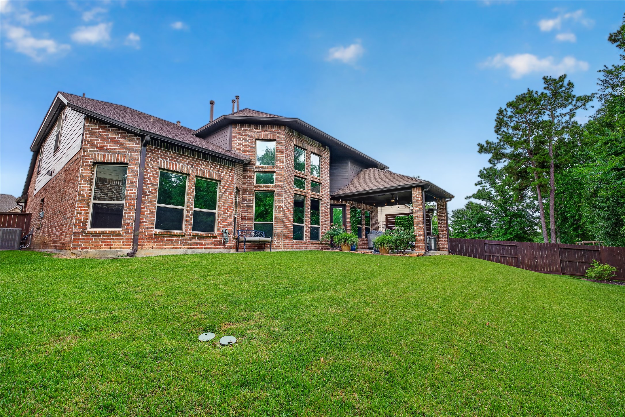 7907 Augusta Creek Court Spring, TX 77389 - Photo 44 of 49 This striking brick home features large windows and a covered patio, situated on a spacious, well-maintained lawn with surrounding trees for added privacy.