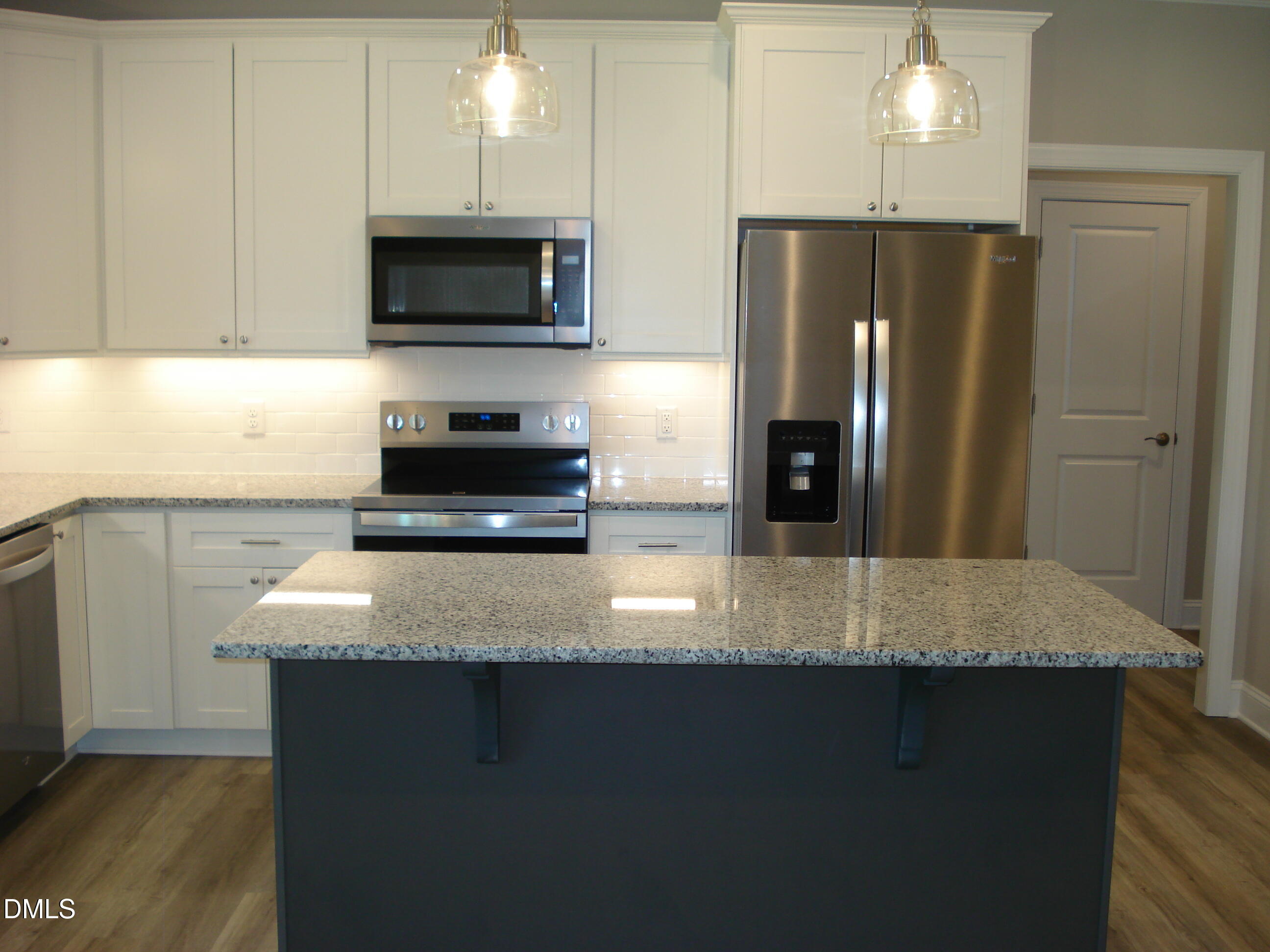 93 Big J Street Erwin, NC 28339 - Photo 25 of 56 a kitchen with stainless steel appliances granite countertop a refrigerator a stove and a sink with wooden floors