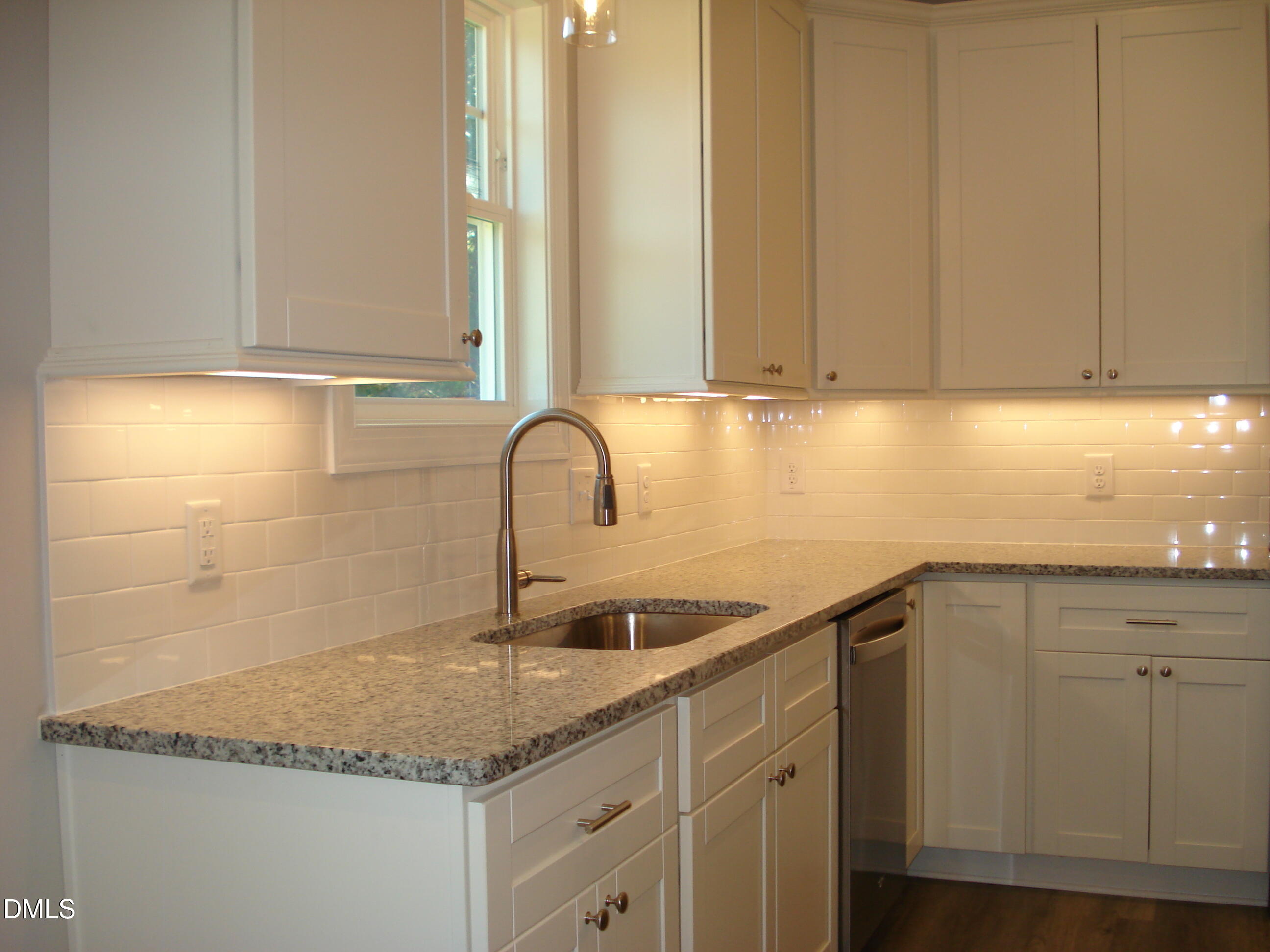 93 Big J Street Erwin, NC 28339 - Photo 28 of 56 a kitchen with granite countertop a sink and white cabinets