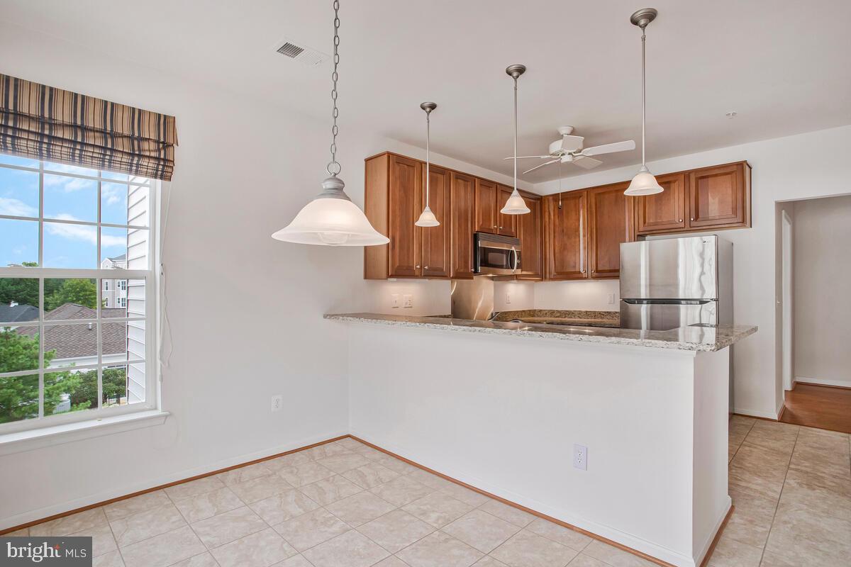 7315 Brookview Road, Unit 302 Elkridge, MD 21075 - Photo 21 of 68 a view of a kitchen with stainless steel appliances granite countertop cabinets and a chandelier