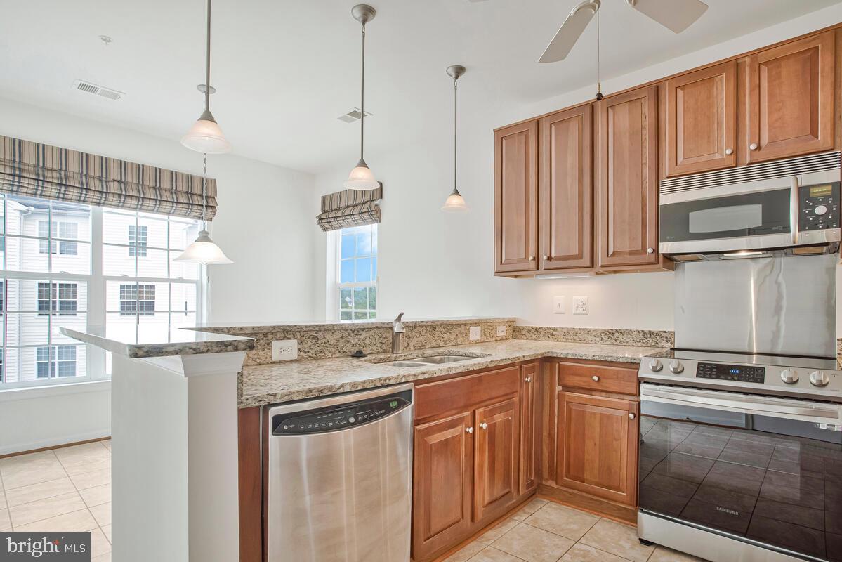 7315 Brookview Road, Unit 302 Elkridge, MD 21075 - Photo 22 of 68 a kitchen with stainless steel appliances granite countertop a sink stove and cabinets