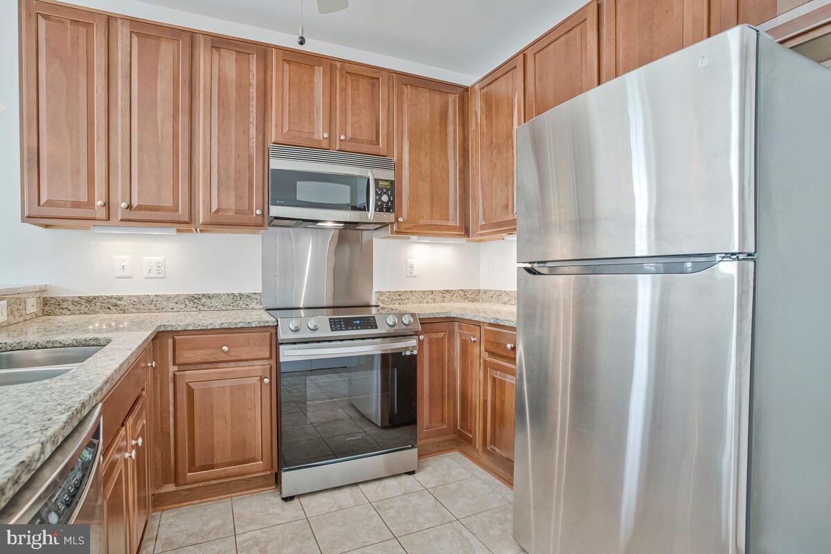 7315 Brookview Road, Unit 302 Elkridge, MD 21075 - Photo 23 of 68 a kitchen with stainless steel appliances granite countertop a refrigerator sink and stove