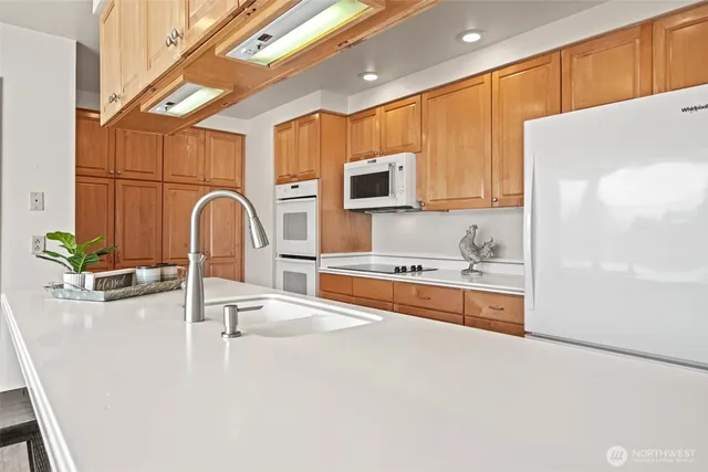 a kitchen with stainless steel appliances granite countertop a sink a stove and a refrigerator