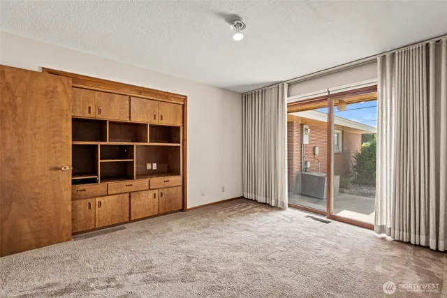 a view of an empty room with a cabinet and workspace