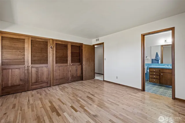 an empty room with wooden floor and a bathroom