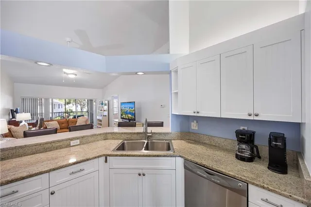 a kitchen with a sink dishwasher and white cabinets