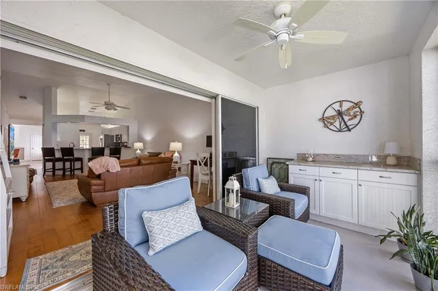 a living room with furniture kitchen view and a chandelier