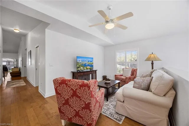 a living room with furniture a window and a ceiling fan