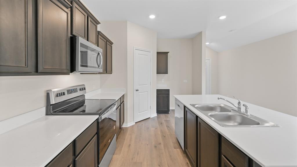 210 Pheasant Run Road Terrell, TX 75160 - Photo 4 of 28 a kitchen that has a sink a stove and a wooden floor