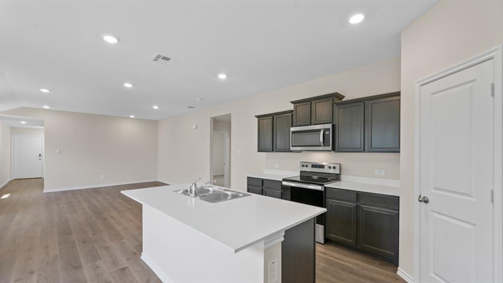 210 Pheasant Run Road Terrell, TX 75160 - Photo 7 of 28 a kitchen with a sink stainless steel appliances and white cabinets