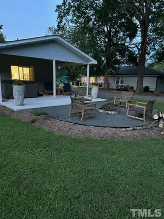 a view of a backyard with table and chairs under an umbrella