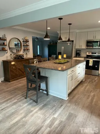 a kitchen with stainless steel appliances granite countertop a stove and a wooden floors