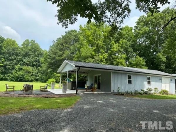 a view of a house with backyard and trees