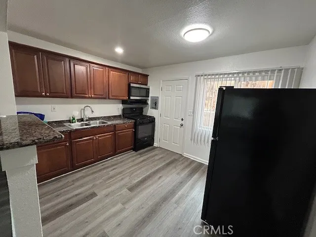 a kitchen with granite countertop a refrigerator stove and sink