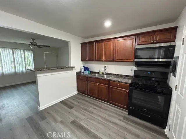 a kitchen with granite countertop wooden cabinets and stainless steel appliances