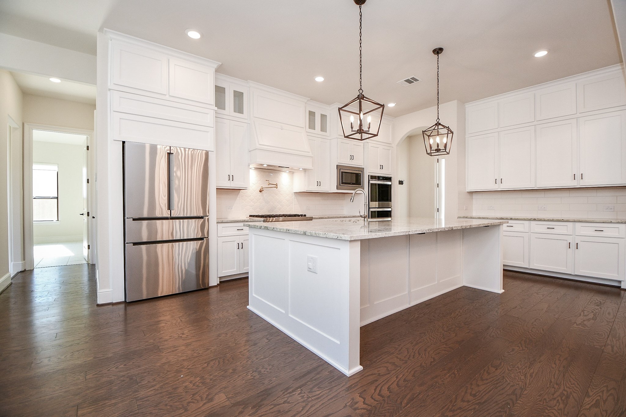 8526 Tombron Grove Road Magnolia, TX 77354 - Photo 12 of 50 a kitchen with stainless steel appliances granite countertop a refrigerator a stove a sink dishwasher a refrigerator and white cabinets with wooden floor