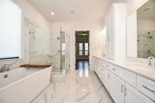 a bathroom with a granite countertop sink mirror and a bathtub