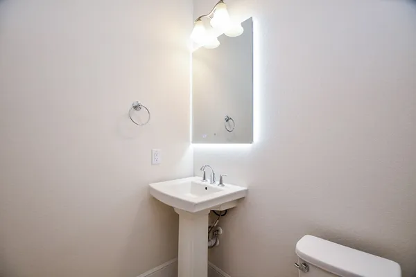 a bathroom with a sink a toilet and mirror