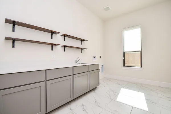a view of a utility room with cabinets