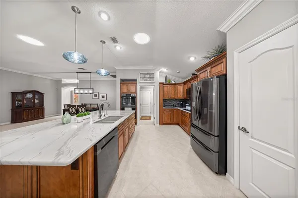 a large kitchen with kitchen island a large counter space a sink appliances and cabinets