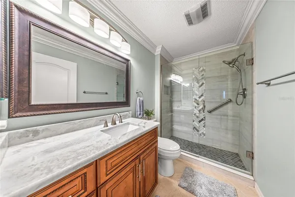 a bathroom with a granite countertop sink toilet and shower