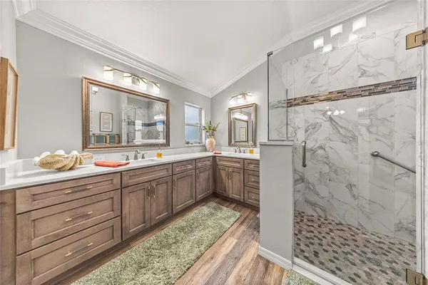 a bathroom with a granite countertop sink a mirror and shower