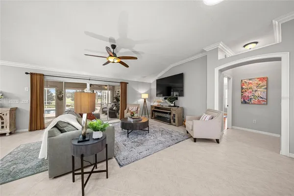 a living room with furniture ceiling fan and a window
