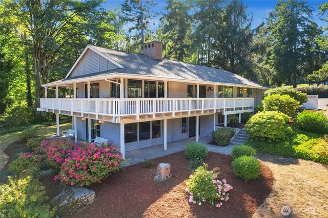 a front view of a house with a yard and potted plants